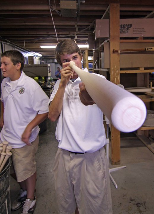 Potter Baseball Tour player inspecting wooden bat