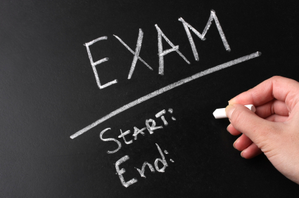 Teacher writing Exam start and finish on blackboard