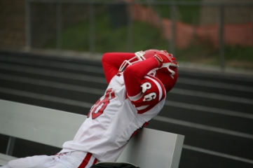 Football player holding head with both hands