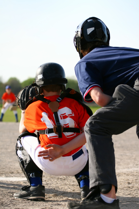 Home plate umpire behind catcher giving sign