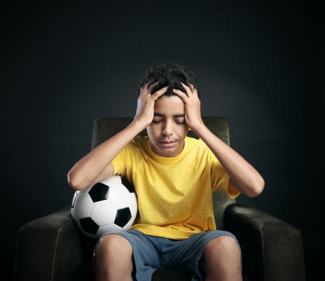 Soccer boy with hands on head