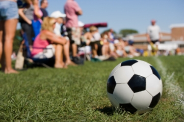 Soccer ball with parents in background