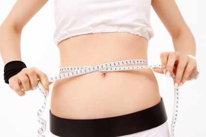 Sporty women measuring waist with tape