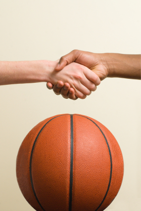 Boys shaking hands with basketball in background