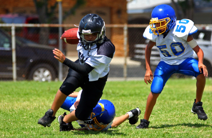 Football running back breaking tackle